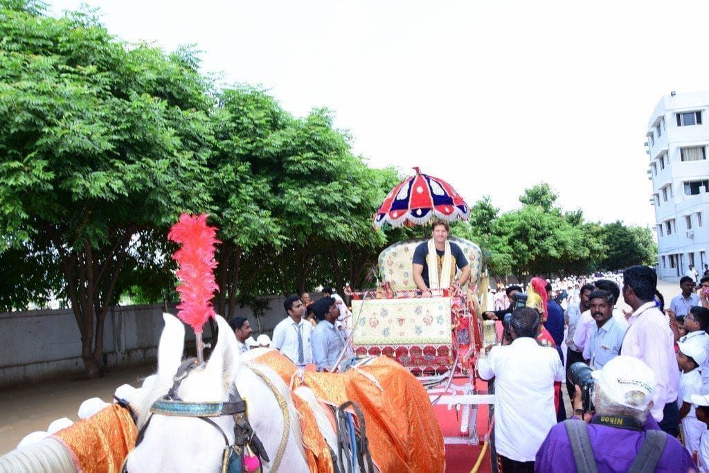 Horse-drawn chariot procession welcoming a cricket legend